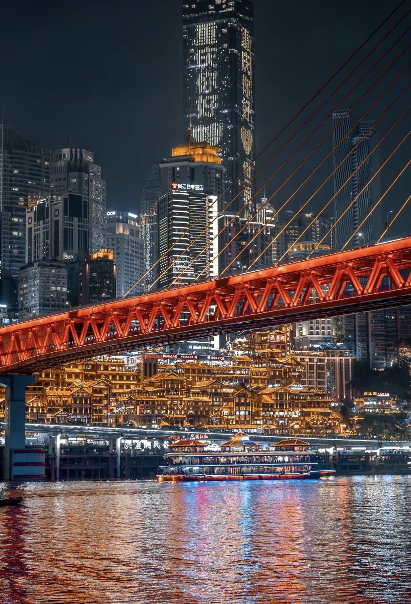 Qiansimen Bridge and Hongyadong stilted houses lit up at night over the Jialing River, Chongqing