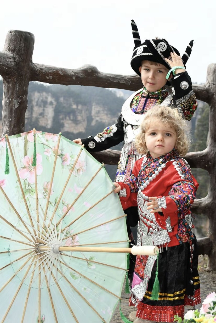 Children in colourful Miao dress with oil-paper umbrellas at a Hanfu & Miao photography session in Zhangjiajie