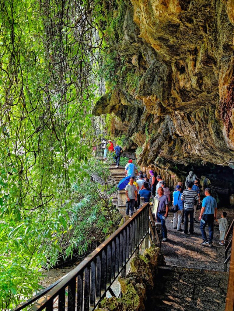 Visitors on the cliff walkway that passes behind the Furong Ancient Town waterfall
