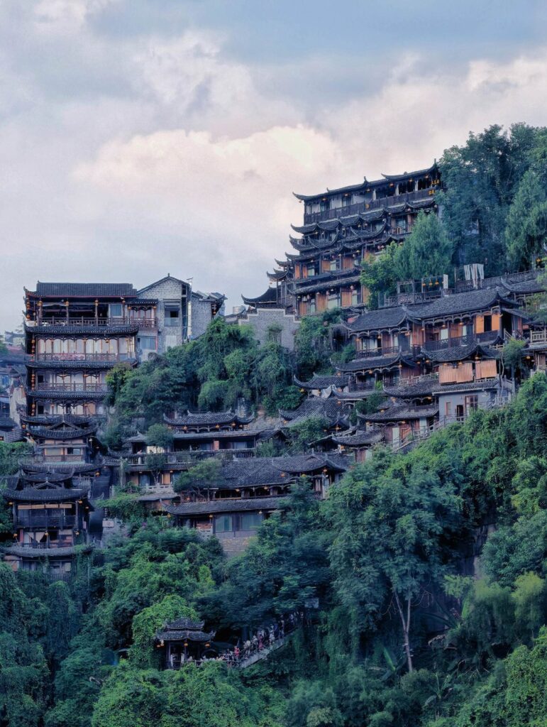 Tujia stilt houses of Furong Ancient Town stacked up the hillside at dusk