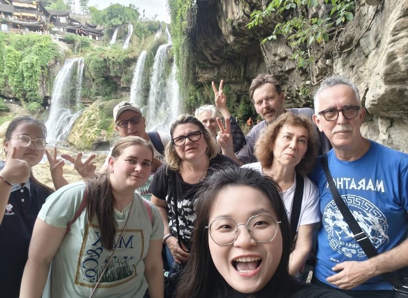 Our Zhangjiajie-based guide with overseas guests at Furong Town waterfall during a private tour