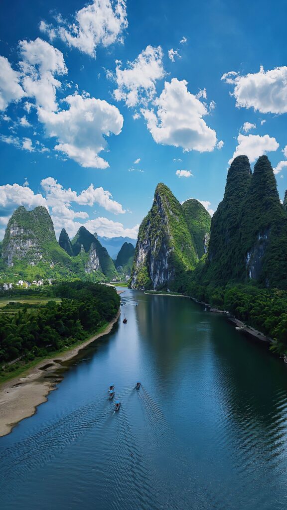 Aerial view of the Li River winding between green karst peaks near Yangshuo, Guilin, China, with small boats on the water.