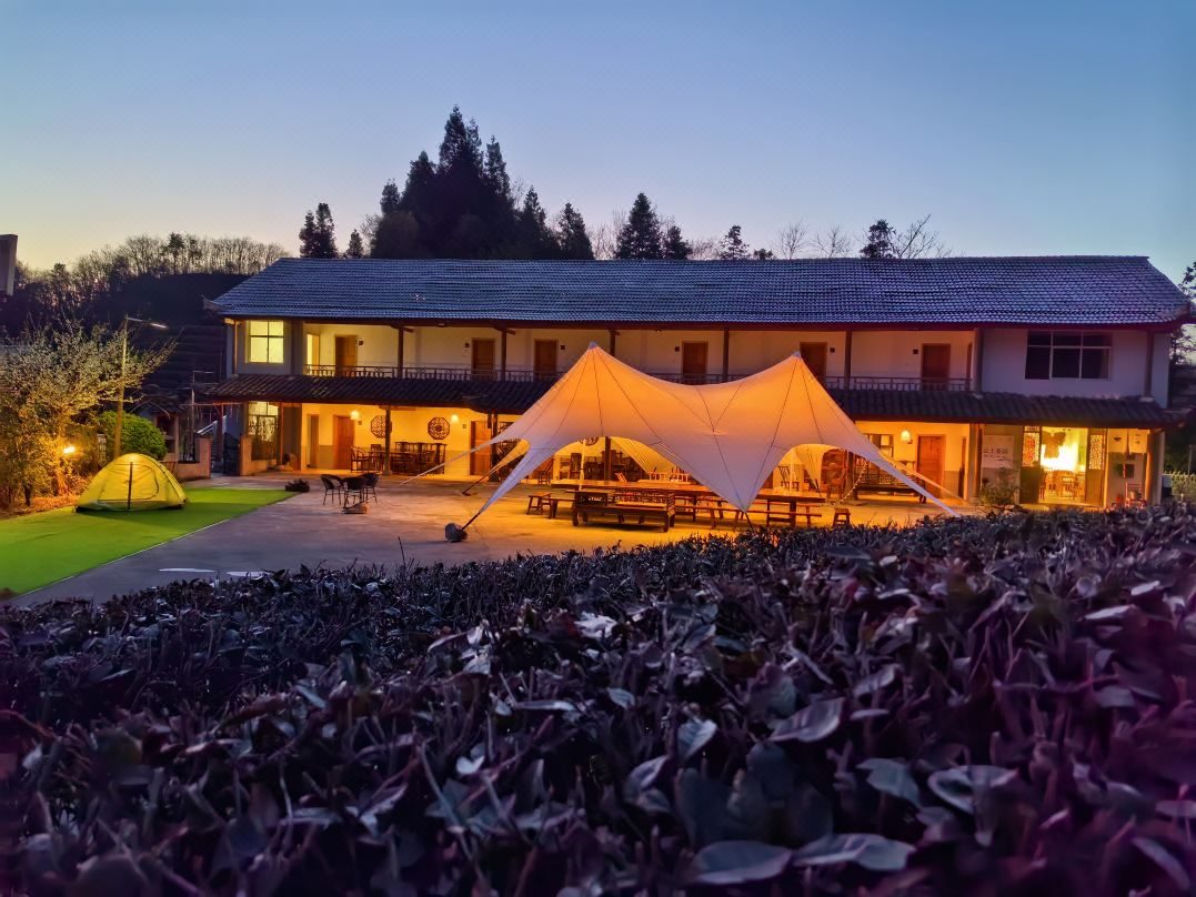 Cloud-top Tea Garden guesthouse and star-tent courtyard at dusk in Zhangjiajie