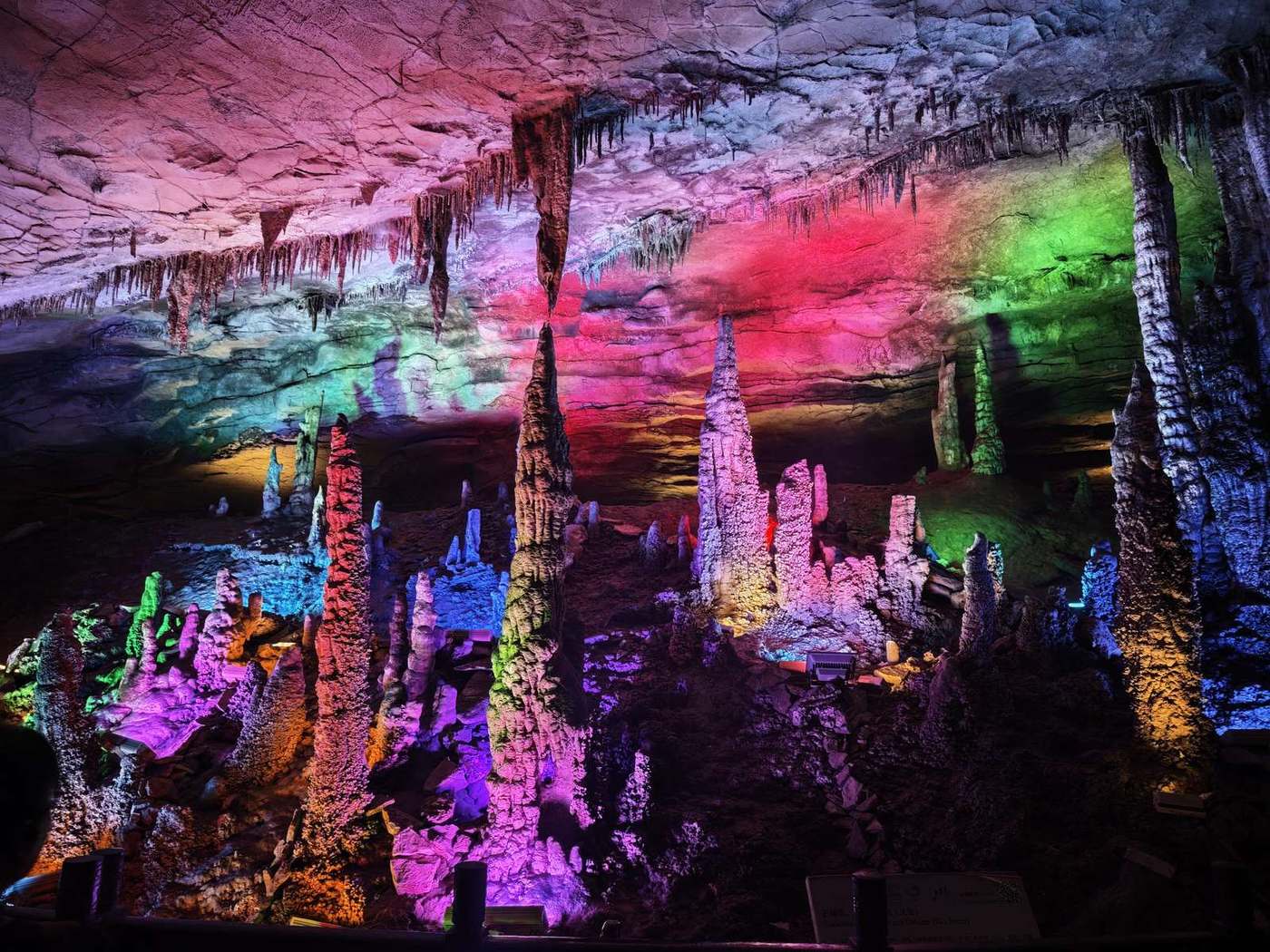 Stone Pillar Street in Huanglong Cave, Zhangjiajie: rows of stalagmites and stalactites under coloured lighting in a wide hall