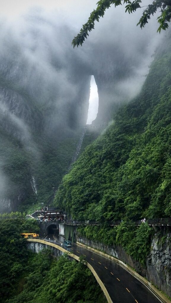 Tianmen Cave and the 999 steps in low cloud, seen from the mountain road and tunnel gate below