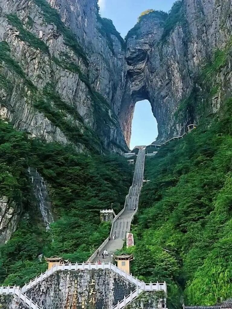 The 999 steps rising from the Stairway to Heaven gateway to Tianmen Cave, with a waterfall on the cliff beside them