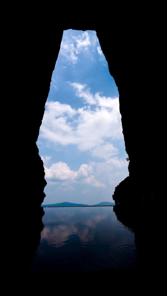 Looking out through Tianmen Cave from inside the arch, with the sky reflected in a pool of water