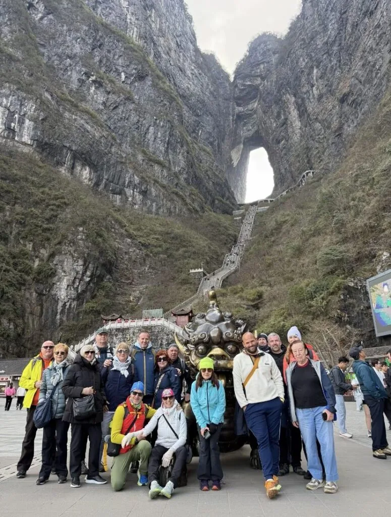 Group of senior travellers at the foot of the stairway up to Tianmen Cave on Tianmen Mountain