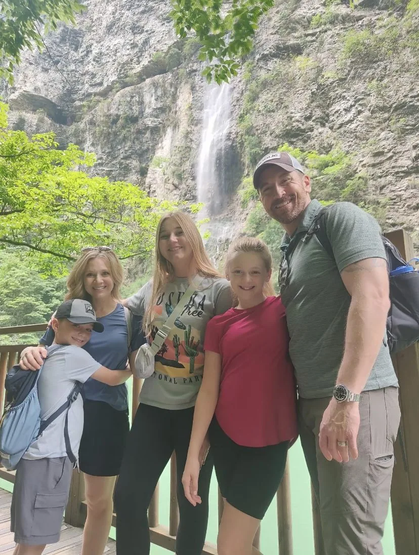 Family of five in front of a waterfall on a private Zhangjiajie tour
